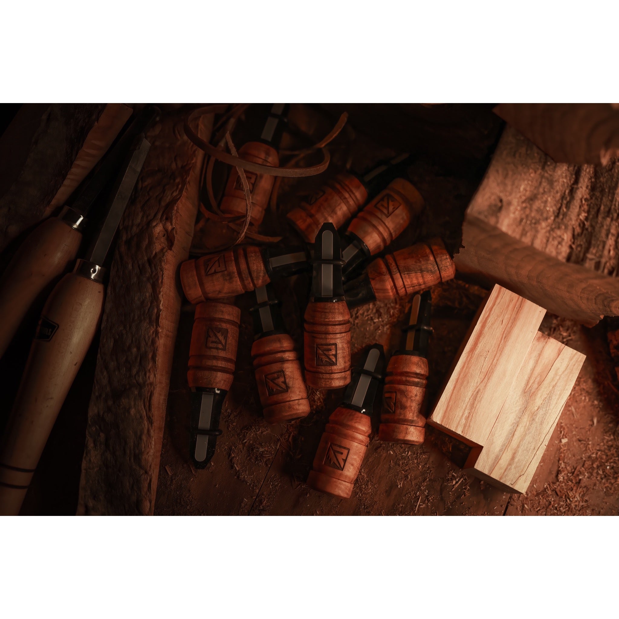 Riven’s Menace-Maple handcrafted wooden bottle stoppers with dark metal tops rest on a rustic workbench amid woodworking tools, wood shavings, and an unfinished wood block.