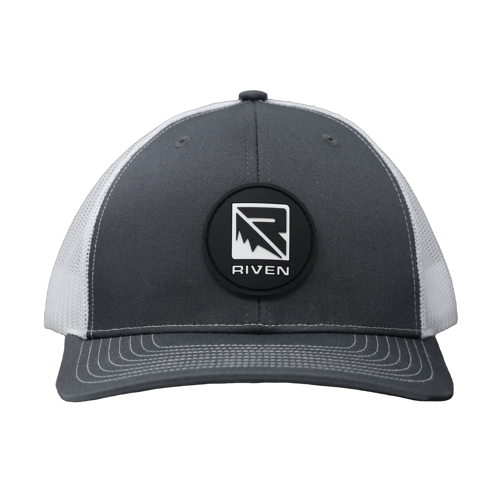 The Riven Patch Hat is a gray and white trucker hat with a round black patch displaying the RIVEN logo in white. It features a mesh snapback for adjustable, comfortable fit.